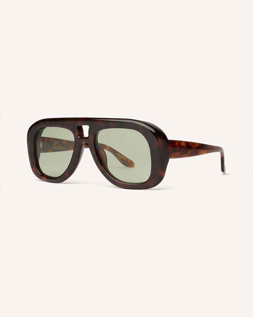 Angled view of chunky acetate frame in an aviator shape. You can really see the thickness of the frame. Tortoise frame with green lenses.