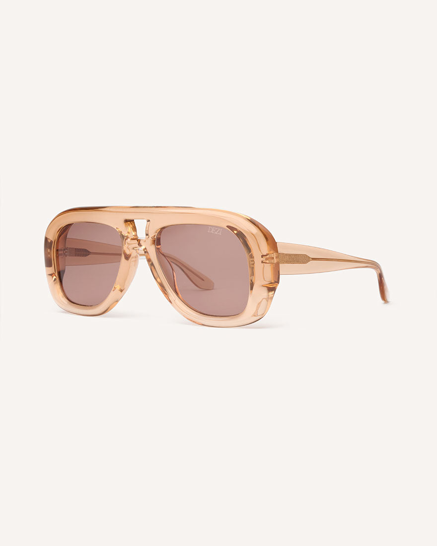 Angled view of chunky acetate frame in an aviator shape. Peach Frame with brown lenses.